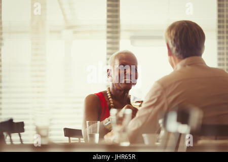 Senior couple drinking wine, dining at restaurant table Stock Photo