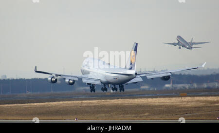 FRANKFURT, GERMANY - FEB 28th, 2015: The Lufthansa Boeing 747 - MSN 26427 - D-ABVN, named Dortmund landing at Frankfurt International Airport FRA and a starting plane in the background. The famous and powerfull aircraft nicknamed as Jumbo has first flight in 1969. The type largest operators are British Airways, Lufthansa, Korean Air and China Airlines Stock Photo