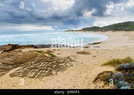 Winter storm clouds approach the sandy beach blocking the Margaret River river mouth in Prevelly, Western Australia Stock Photo