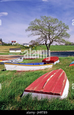 Wooden dinghie boats sit on the ground near a small bay in Bailey Island, Maine, USA. Stock Photo