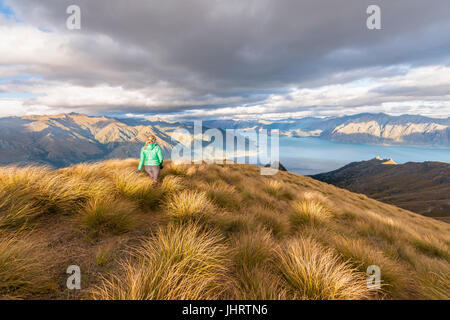 Hiking woman looking at lake, Lake Hawea and mountain landscape, Isthmus Peak, Otago, South Island, New Zealand
