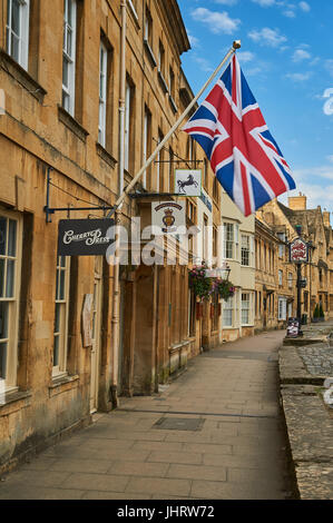 Chipping Campden High Street and a Union Jack flag flying from the from of a stone building in the Cotswold market town. Stock Photo