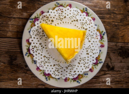 Lemon Tart slice isolated on a wood background Stock Photo