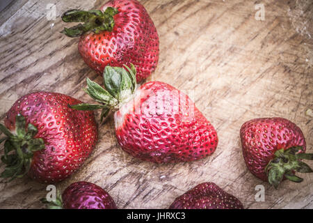 Photograph of some strawberries on wood cutting board Stock Photo