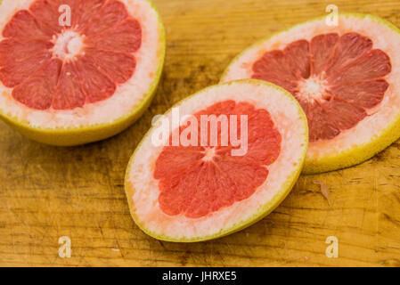 Photograph of some grapefruit slices on wood cutting board Stock Photo
