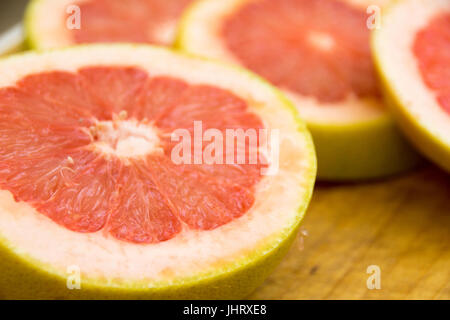 Photograph of some grapefruit slices on wood cutting board Stock Photo