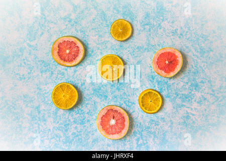 Photograph of some grapefruit slices on light blue background Stock Photo