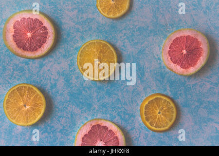 Photograph of some grapefruit slices on light blue background Stock Photo