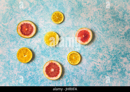 Photograph of some grapefruit slices on light blue background Stock Photo