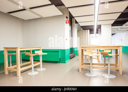 At a university school in the hallway there are several tables and chairs Stock Photo