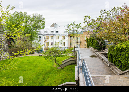 Quebec City, Canada - May 30, 2017: Old town street sidewalk with apartment buildings and Parc du Cavalier du Moulin Stock Photo