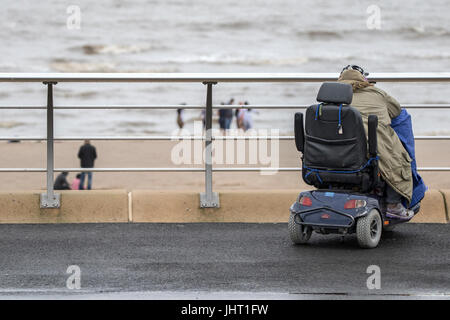 Blackpool, Lancashire, 15th July 2017. UK Weather.  Bad summer weather doesn't deter these holidaymakers from having a good time down at the beach on Blackpool seafront.  Heavy rain is expected to last all day with a chance of some brighter spells in the early evening.  Credit: Cernan Elias/Alamy Live News Stock Photo