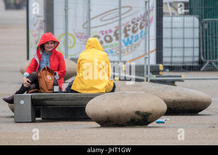 Blackpool, Lancashire, 15th July 2017. UK Weather.  Bad summer weather doesn't deter these holidaymakers from having a good time down at the beach on Blackpool seafront.  Heavy rain is expected to last all day with a chance of some brighter spells in the early evening.  Credit: Cernan Elias/Alamy Live News Stock Photo