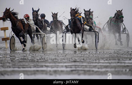 Cuxhaven, Germany. 16th July, 2017. Horses can be seen running on the tidal flats along the beach of Duhnen in Cuxhaven, Germany, 16 July 2017. The traditional tidal flat race in Duhnen is a tourist attraction at the North Sea Coast. The horses vie for victory and financial rewards along the tidal flats along the coast. Photo: Ingo Wagner/dpa/Alamy Live News Stock Photo