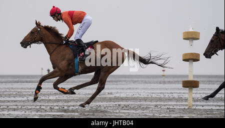 Cuxhaven, Germany. 16th July, 2017. Horses can be seen running on the tidal flats along the beach of Duhnen in Cuxhaven, Germany, 16 July 2017. The traditional tidal flat race in Duhnen is a tourist attraction at the North Sea Coast. The horses vie for victory and financial rewards along the tidal flats along the coast. Photo: Ingo Wagner/dpa/Alamy Live News Stock Photo