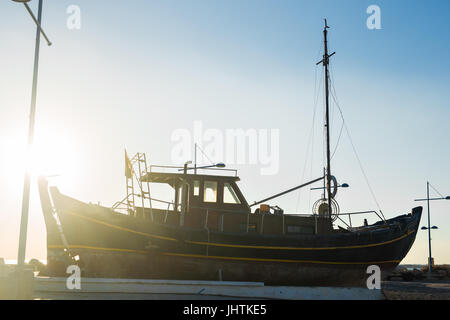 Small ship at sunset Stock Photo