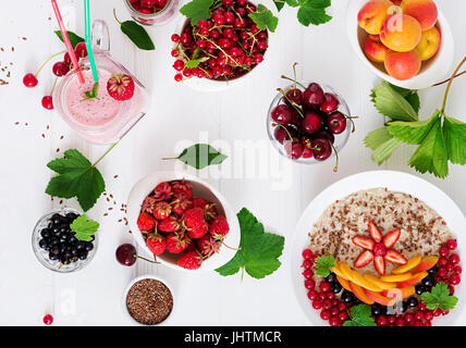Tasty and healthy oatmeal porridge with berry, flax seeds and smoothies. Healthy breakfast. Fitness food. Proper nutrition. Top view. Flat lay Stock Photo