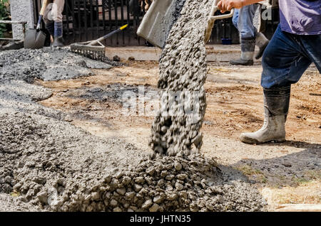 Men pouring concrete mix on road Stock Photo