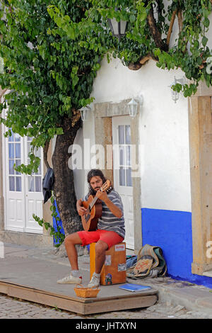 street musician plays guitar whitewashed village of Obidos Estremadura Portugal Stock Photo