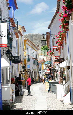 Tourists flock to shops on the narrow stone streets whitewashed village of Obidos Estremadura Portugal Stock Photo