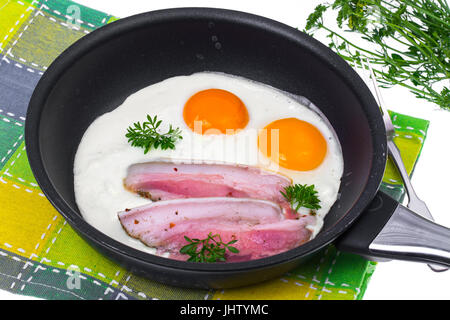 Fried eggs and bacon in frying pan on white background. Studio Photo Stock Photo