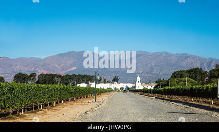 Cafayate, Argentina - December 4, 2014: Road to the old colonial wine maker 'Bodega El Esteco' in Cafayate with the mountains and clear blue sky in th Stock Photo