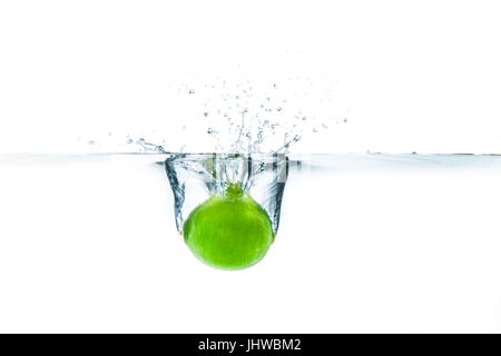 Fresh lime dropped into the water with water splash on a white background Stock Photo