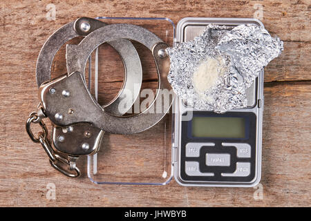 Handcuffs, digital scales, heroin close up. Stock Photo
