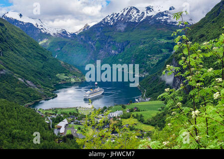 Scenic view to village at end of Geirangerfjorden fjord with cruise ships moored in summer. Geiranger Sunnmøre region Møre og Romsdal Norway Stock Photo