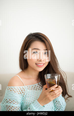 Asian woman drinking her morning tea over a breakfast at home. Stock Photo