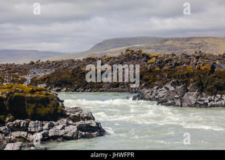 Fast flowing river cutting through an extensive lave field in southern Iceland Stock Photo