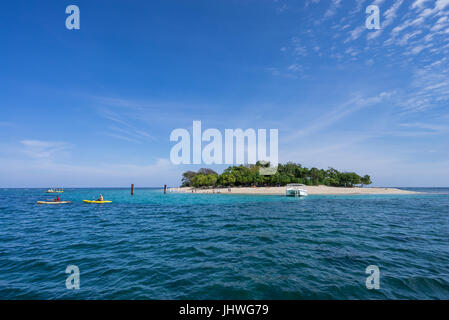 Two fishermen paddle their kayaks from the tiny island of Isle La Rat in the Baie de l'Acul off the north coast of Haiti, near the town of Labadie. Stock Photo