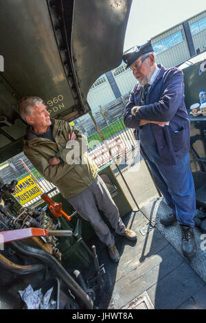 The driver of ex-GWR loco 6960 'Raveningham Hall' chats to a visitor on the footplate in Bishops Lydeard station on the West Somerset Railway, UK