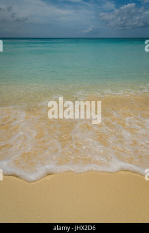 Wave gently rolling up the beach in Grand Cayman. Stock Photo