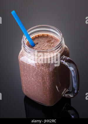 Milkshake chocolate in jar with a straw on black background Stock Photo