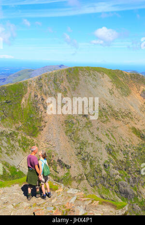 Man and woman enjoying view from summit of Mount Snowdon, Gwynedd, Snowdonia, north Wales, UK Stock Photo