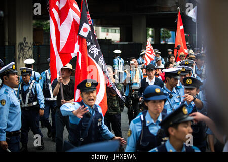 TOKYO, JAPAN - JULY 16: Japanese nationalists holding Japanese maritime flags, escorted by police, took to the streets in a 'hate demonstration' in Akihabara, Tokyo, Japan on July 16, 2017. The nationalists faced off with anti-racist groups who mounted counter protests demanding an end to hate speech and racism in Japan. Credit: Richard Atrero de Guzman/AFLO/Alamy Live News Stock Photo