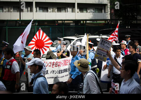 TOKYO, JAPAN - JULY 16: Japanese nationalists holding Japanese maritime flags, escorted by police, took to the streets in a 'hate demonstration' in Akihabara, Tokyo, Japan on July 16, 2017. The nationalists faced off with anti-racist groups who mounted counter protests demanding an end to hate speech and racism in Japan. Credit: Richard Atrero de Guzman/AFLO/Alamy Live News Stock Photo