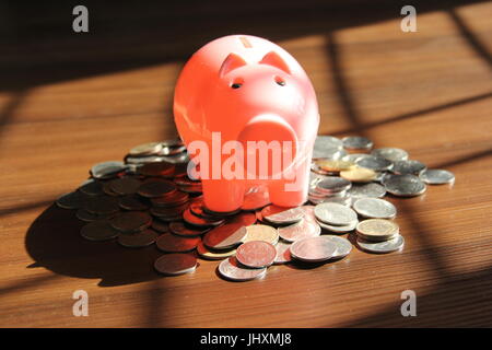 Pink colored piggy bank with Indian rupees coins, financial concept Stock Photo