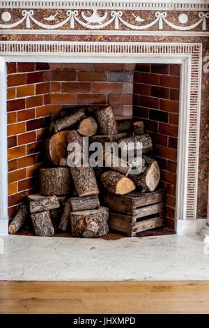 Early 20th century fireplace refurbished, ornate and stacked with a log pile, Ireland Stock Photo