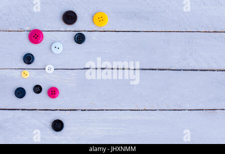 Several multicolored buttons on a wooden background. Stock Photo
