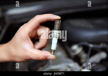 Auto mechanic holds an old spark plug Stock Photo
