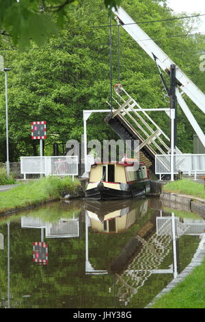 Road rising on the swing bridge at Talybont on Usk, Wales to allow narrow boats to proceed on the Monmouthshire and Brecon Canal as road traffic waits Stock Photo