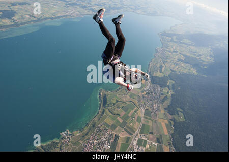 A woman making a fun skydive above lake Neuchatel in Switzerland Stock Photo