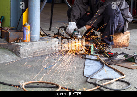 A person angle grinding on metal Stock Photo