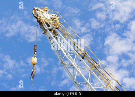 Crane arm with large hook on a construction site. Stock Photo