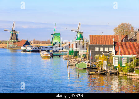 Wood houses and windmill reflected in the blue water of River Zaan, Zaanse Schans, North Holland, The Netherlands, Europe Stock Photo