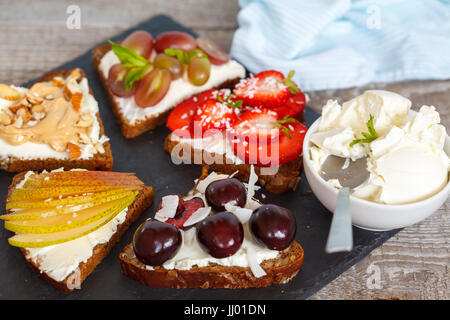 Sweet sandwiches with mascarpone cheese and berries, pear and peanut butter. Stock Photo