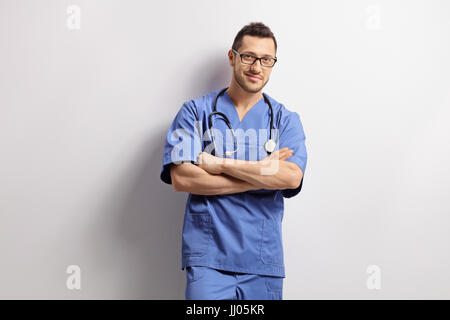 Doctor with his arms crossed leaning against a wall Stock Photo