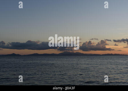 island of langkawi, malaysia seen from kuala perlis shrouded in cloud during sunset Stock Photo